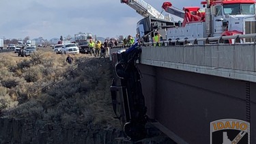 2 people + 2 dogs rescued from truck dangling from bridge