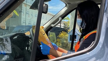 Angela, a delivery worker for Amazon Prime, wears a mask and gloves on her route in Los Angeles on April 8, 2020.