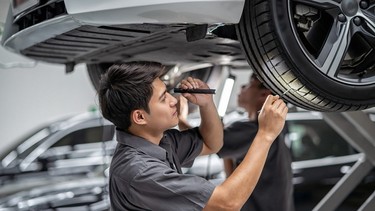 mechanic Checking and torch tire in maintainance service center which is a part of showroom, technician or engineer professional work for customer, car repair concept