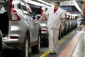 Produktionsmitarbeiter inspizieren am 30. März 2015 im Honda-Werk in Alliston, Ontario, am Fließband fahrende Autos.