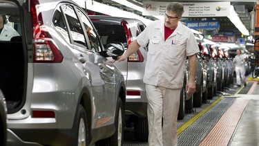Production Associates inspect cars moving along assembly line at Honda manufacturing plant in Alliston, Ontario March 30, 2015.