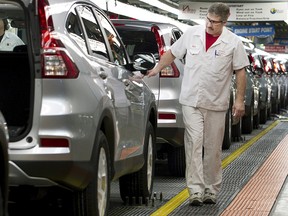 Production Associates inspect cars moving along assembly line at Honda manufacturing plant in Alliston, Ontario March 30, 2015.