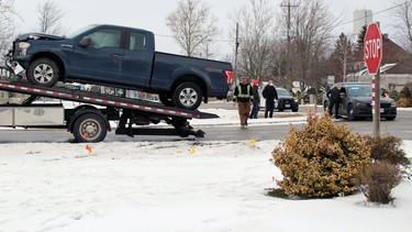 A blue Ford F-150 with a crumpled front end was taken away on a flatbed tow truck after a two-car crash on Sunday January 31, 2021 in Brigden, Ont.