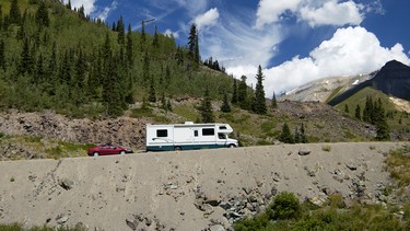 An RV camper towing a car through the Colorado mountains