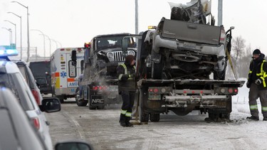 Two vehicles are loaded onto tow trucks following a fatal collision on the west Perimeter Highway between Portage Avenue and Roblin Boulevard in Winnipeg on Mon., Jan. 25, 2021.