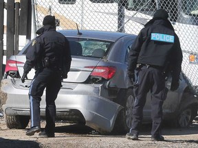 Essex County OPP officers examine the silver sedan that led police on a dangerous chase on Highway 401 and County Road 42 on March 2, 2021.