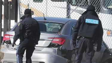 Essex County OPP officers examine the silver sedan that led police on a dangerous chase on Highway 401 and County Road 42 on March 2, 2021.