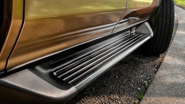 A close-up of the accessory running board of an SUV