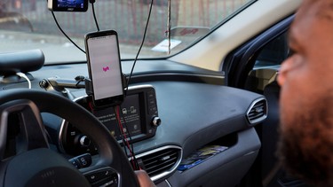 FILE PHOTO: Uber and Lyft driver Adama Fofana sits in his car in New York City