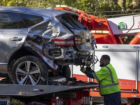 A tow truck operator secures the car that golf legend Tiger Woods was driving when seriously injured in a rollover accident on February 23, 2021 in Rolling Hills Estates, California.