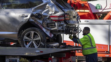 A tow truck operator secures the car that golf legend Tiger Woods was driving when seriously injured in a rollover accident on February 23, 2021 in Rolling Hills Estates, California.