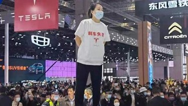 Woman protests atop Tesla Model 3 in Shanghai