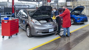 A student in the Battery Electric Vehicle Technology and Service course gets instruction by a BCIT instructor.