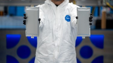 A Solid Power manufacturing engineer holds two 20 ampere hour (Ah) all solid-state battery cells for the BMW Group and Ford Motor Company, at Solid Power's pilot production line in Louisville, Colorado, U.S. April 23, 2021.