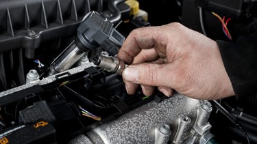 Mechanic checks the ignition plugs of a modern car