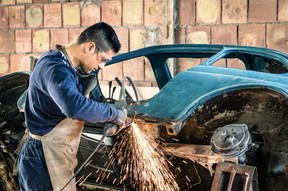 A young man working on an old Fiat