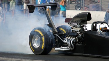 A top fuel dragster burning rubber at the start of a drag race.