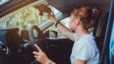 Safety driving woman adjust the car rearview mirror in interior before start travel trip every time.