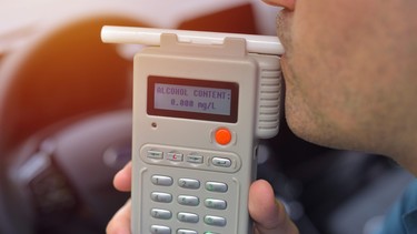 A driver blowing on a breathalyzer