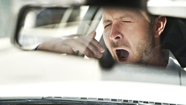 fatigue A man yawn in his car because is so tired