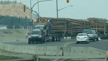 A Ram and a loaded logging truck in an intersection in B.C. in July 2021.