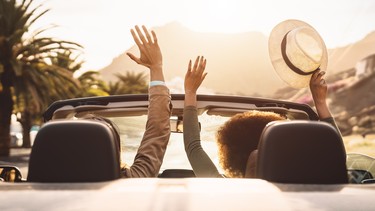 A pair of people on a road trip in a convertible