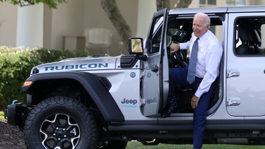 U.S. President Joe Biden hops out after test driving a Jeep Wrangler 4xe Rubicon during an event for clean cars and trucks, and signs an executive order on transforming the country’s auto fleet at the White House in Washington, U.S. August 5, 2021.