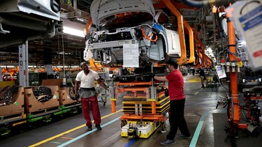 General Motors assembly workers connect a battery pack underneath a partially assembled 2018 Chevrolet Bolt EV vehicle on the assembly line at Orion Assembly in Lake Orion, Michigan, U.S.,