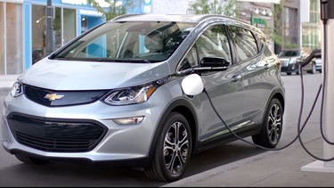 A 2017 Chevrolet Bolt charging on a curbside EV charger