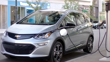 A 2017 Chevrolet Bolt charging on a curbside EV charger