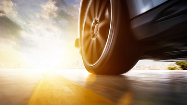 Low angle side view of car driving fast at sunset with motion speed effect .