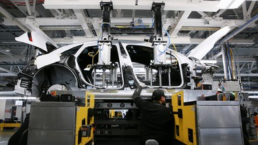 Workers marry the body structure with the battery pack and the front and rear sub frames as they assemble electric vehicles at the Lucid Motors plant in Casa Grande, Arizona, U.S. September 28, 2021.