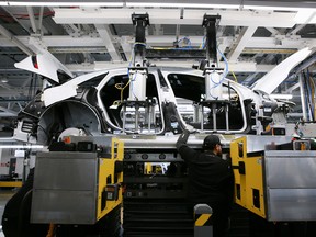 Workers marry the body structure with the battery pack and the front and rear sub frames as they assemble electric vehicles at the Lucid Motors plant in Casa Grande, Arizona, U.S. September 28, 2021.