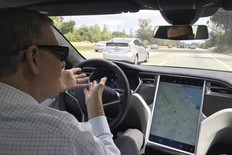 Reuters journalist Paul Ingrassia sits in the drivers seat of a Tesla Model S in Autopilot mode in San Francisco, California, U.S., April 7, 2016