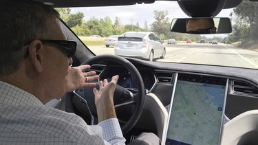 Reuters journalist Paul Ingrassia sits in the drivers seat of a Tesla Model S in Autopilot mode in San Francisco, California, U.S., April 7, 2016.