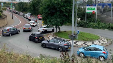 An aerial view shows customers queueing in their cars to access an Asda petrol station in east London on September 25, 2021.