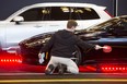 Oliver Auer dusts an Aston Martin DB11 on display at a previous Vancouver International Auto Show at the Vancouver Convention Centre