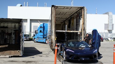 A McLaren GT being loaded into the trailer of a TFX International truck