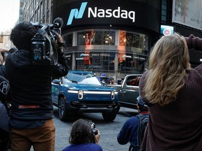 Journalists photograph a Rivian R1T pickups, the Amazon-backed electric vehicle (EV) maker, during the company’s IPO outside the Nasdaq Market site in Times Square in New York City, U.S., November 10, 2021.