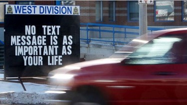 Motorists make their way past an anti distracted driving sign.