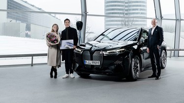 The owners of the millionth BMW electrified vehicle produced, a 2022 ix, pose at BMW Welt