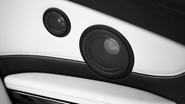 Close up shot of two round speakers in a car.