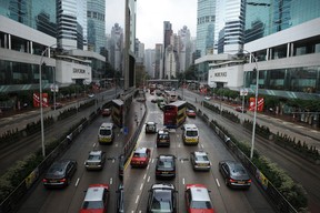 Eine Reflexion (L) spiegelt eine Szene aus Büros und Einkaufszentren in Hongkong am 19. März 2011 wider.