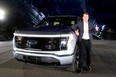 Ford CEO Jim Farley poses with the all-electric Ford F-150 Lightning pickup truck during the unveiling at the company's world headquarters in Dearborn, Michigan, U.S., May 19, 2021.