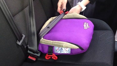 A Bubblebum inflatable child booster seat being installed in a car