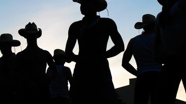 A silhouette image of a gathering of cowboys