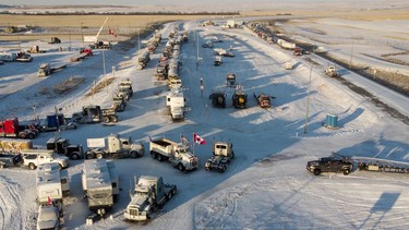 A truck convoy of anti-COVID-19 vaccine mandate demonstrators block the highway on Feb. 2 at the busy U.S. border crossing in Coutts, Alta.