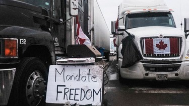 Protesters against vaccine mandates with trucks and other vehicles adorned in signs and Canadian flags gather on ON-3 near Ambassador Bridge on Wednesday in Windsor, Ontario.
