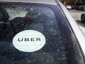 An Uber window sticker in the windshield of a car