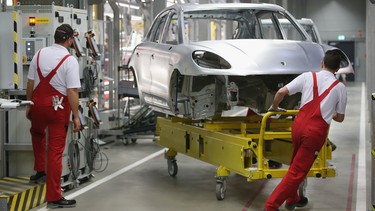 Workers prepare the body of a Porsche Macan SUV at the Porsche Macan factory at the Porsche plant on February 11, 2014 in Leipzig, Germany.